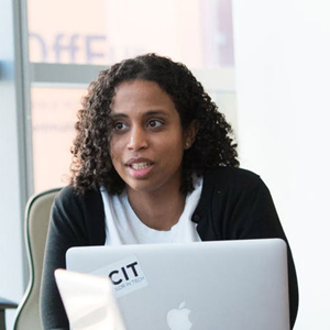 woman sitting a table with a laptop in front of her